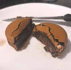 Macaron de chocolate aberto mostrando o recheio