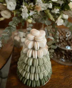 Torre de macarons verdes e brancos com decoração floral